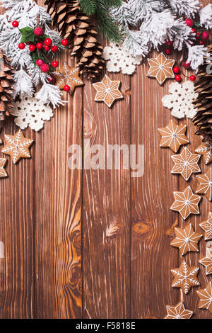 Rahmen von Pfefferkuchen und Winter Dekor auf einem hölzernen Hintergrund. Stockfoto