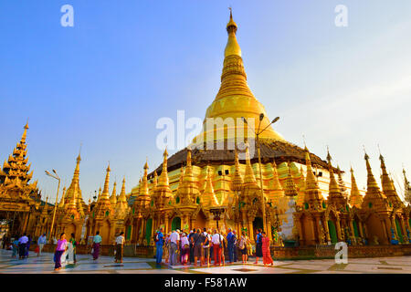Touristen versammeln sich um Führer auf späten Nachmittag Tour in Shwedagon Pagode, Yangon die heiligste buddhistische Pagode in Myanmar, Burma Stockfoto