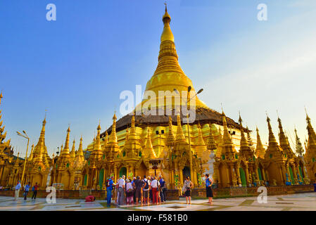 Touristen versammeln sich um Führer auf späten Nachmittag Tour in Shwedagon Pagode, Yangon die heiligste buddhistische Pagode in Myanmar, Burma Stockfoto