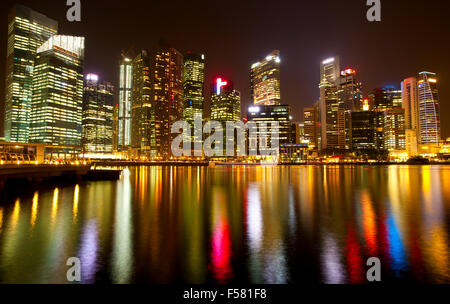 Panorama der modernen Wolkenkratzer Singapur in der Nacht mit lite Wasserspiegelungen. Stockfoto