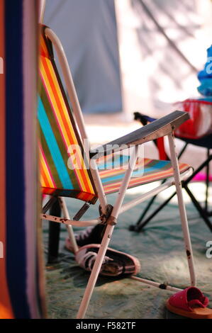 Sonnenliege mit orange, blaue, rote und gelbe Streifen in einem camping-Szene Stockfoto