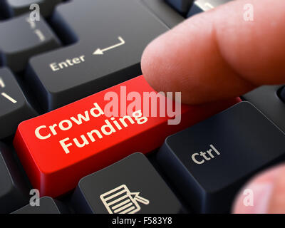 Finanzierung - Menge auf rote Taste geschrieben. Männliche Hand Pressen auf schwarzen PC-Tastatur drücken. Detailansicht. Der Hintergrund jedoch unscharf. Stockfoto