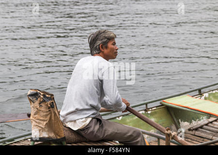 Tam Coc Bereich der Ngo Dong River, vietnamesische männlichen Boot Ruderer erwartet Touristen für eine Tour entlang des Flusses, Vietnam Stockfoto