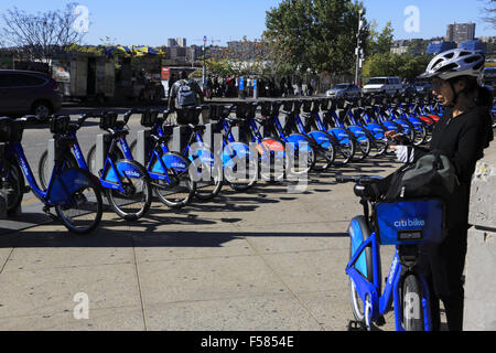 Eine Reiterin mit einer Citibike in einem Citibike sharing Station. West Side von Manhattan New York City USA Stockfoto