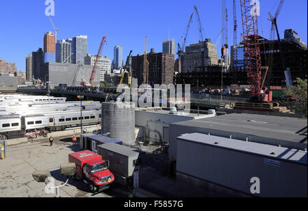 Pendeln Sie Züge anhalten in West Side Hof mit Skyline von New York City im Hintergrund. New York City USA Stockfoto