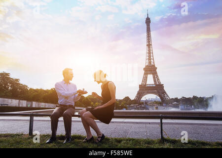 Heirate mich, Vorschlag am Eiffelturm in Paris, schöne Silhouetten der kaukasischen Pärchen Stockfoto