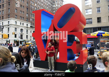 Besucher, die ihre Fotos vor der Love-Skulptur an der 6th Avenue. Midtown Manhattan, New York City, USA Stockfoto