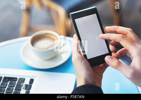 Hände mit Smartphone und Tasse Kaffee Stockfoto
