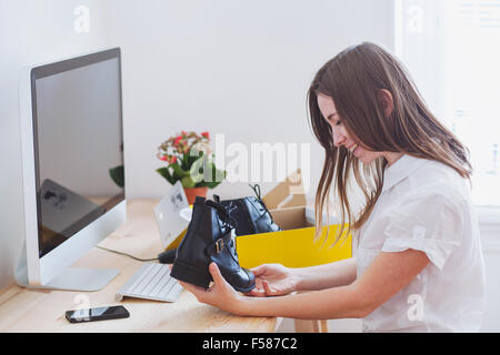 Einkaufen online-Konzept, öffnet glückliche Frau Box mit neuen Schuhen, bestellt per internet Stockfoto