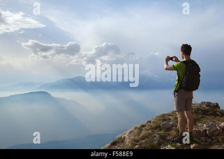 Wanderer nehmen Foto von herrlicher Berglandschaft mit Handy Stockfoto