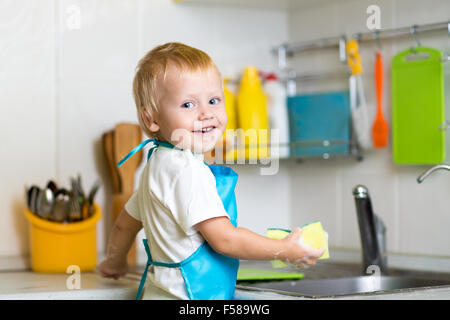 Kleiner Junge Mutter abwaschen in der Küche zu helfen Stockfoto