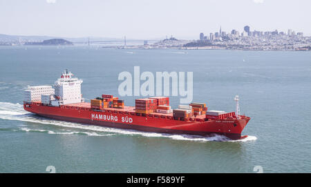 Ein Frachtschiff der Hamburg Süd Gesellschaft segelt in Richtung Golden Gate-Brücke mit der Stadt von San Francisco im Hintergrund. Stockfoto