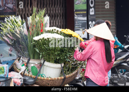 Vietnamesische Blumenverkäuferin mit Fahrrad verkauft Blumen in Hanoi Altstadt, Stadt, Vietnam Stockfoto