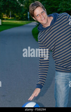 Glückliche junge Kerl spielen Basketball im freien Stockfoto