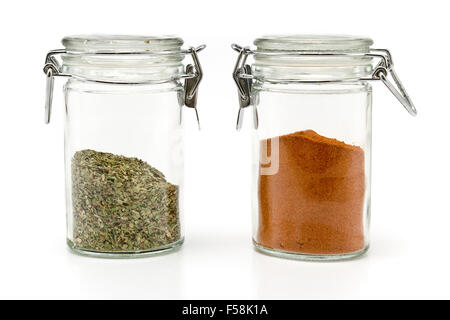 Paprika-Pulver und Oregano in Gläsern isoliert auf weiss Stockfoto
