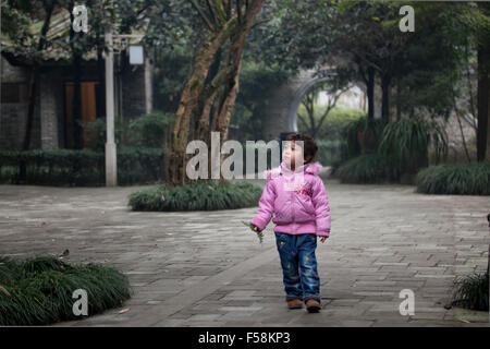 Ein kleines Mädchen entdecken einen alten Garten in einer alten Stadt namens Gucheng in Pixian am Stadtrand von Chengdu in China. Stockfoto