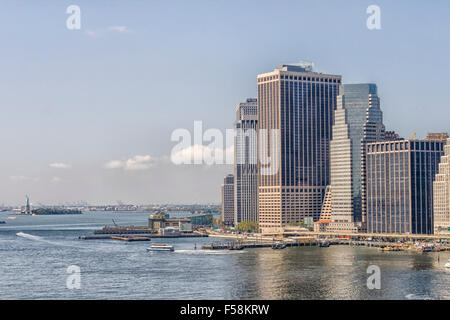 Skyline von Manhattan gesehen von der Brooklyn Bridge mit Blick auf die Freiheitsstatue im Hintergrund Stockfoto