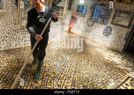 Palazzo Fortuny, Kunstgalerie, Venedig, Italien. Ein Mann wischt nach Überschwemmungen durch Hochwasser Acqua Alta. Stockfoto