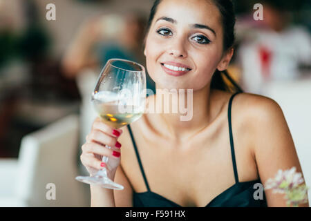 Schöne Frau, die Weinprobe beim Sitzen im restaurant Stockfoto