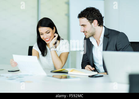 Schöne Geschäftsfrau und ein hübscher Geschäftsmann diskutieren in einem modernen Büro Stockfoto