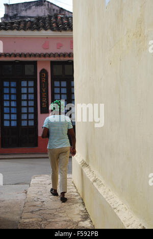 Eine kubanische Frau in Lockenstäbe entlang einer Straße in Remedios, Kuba Stockfoto