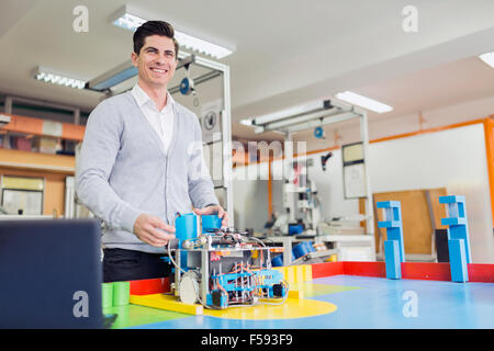 Männliche Elektroingenieur Programmierung eines Roboters während Robotik-Klasse Stockfoto