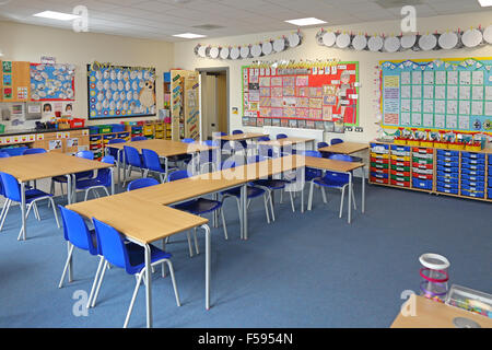 Ein Klassenzimmer in einem neu gebauten UK junior Schule. Schreibtische, Stühle und bunten Schubladen zeigt. Kinder Kunst umfasst die Wand Stockfoto