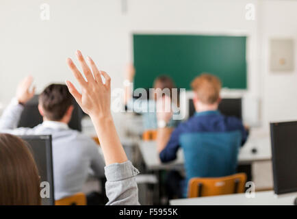 Junge Studenten, die Hände in einem Klassenzimmer zeigen, dass sie bereit sind Stockfoto