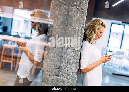 Schöne Frau mit Handy Nachricht zu schreiben Stockfoto