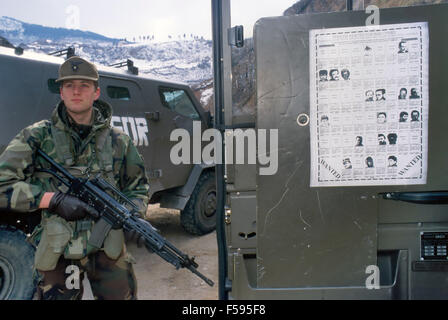 Intervention der NATO in Bosnien und Herzegowina nach dem Dayton-Abkommen, italienische Armee Gebirgstruppen patrouillieren in der Nähe von Sarajevo, Poster mit wollte Kriegsverbrecher - Intervento NATO in Bosnien-Herzegowina, Alpini in Pattuglia Nei Dintorni di Sarajevo, Manifest con ich Criminali di Guerra ricercati Stockfoto