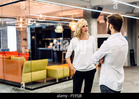 Büro-Gespräch zwischen Kollegen bei der Arbeit Stockfoto