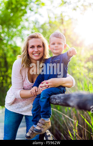 Schöne junge Mutter mit ihren hübschen kleinen Sohn Stockfoto