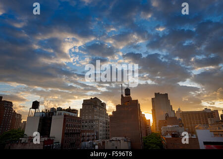 New York City, Chelsea-Viertel und die Skyline bei Sonnenuntergang mit Wassertanks punktiert. Entlang der 8th Avenue, Manhattan, NYC Stockfoto