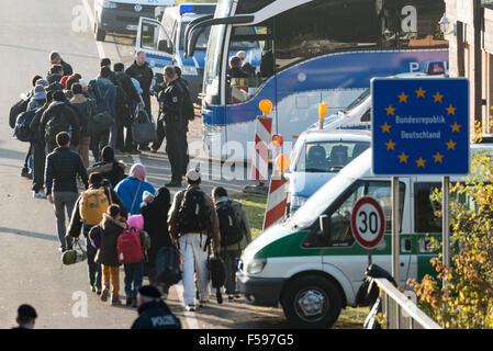 Wegscheid, Deutschland. 30. Oktober 2015. Mitglied der deutschen Bundespolizei direkt Flüchtlinge auf Busse an der deutsch-österreichischen Grenze in der Nähe von Wegscheid, 30. Oktober 2015. Foto: ARMIN WEIGEL/DPA Stockfoto