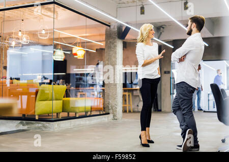 Büro-Gespräch zwischen Kollegen bei der Arbeit Stockfoto