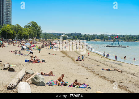 Sonnenanbeter und Badegäste am Strand von English Bay in Vancouver, BC, Kanada Stockfoto