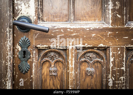 Metall Türgriff und Schlüsselloch auf alten schäbigen braune Holztür auf Haus in Krakau, Polen, Europa. Stockfoto