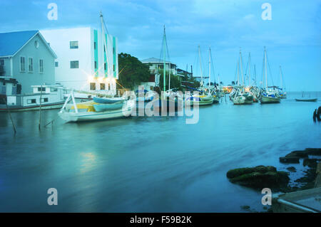 Blick von der historischen Drehbrücke in Belize City in der Abenddämmerung. Der Sandlighters Felsen sanft im Zuge der Haul über Creek. Stockfoto