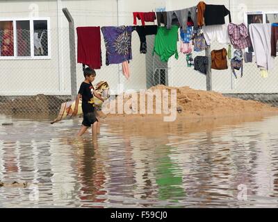 Bagdad, Irak. 30. Oktober 2015. Ein Flüchtling junge geht im Wasser im Alkzenzanah Camp in Bagdad, Irak, 30. Oktober 2015. Hochwasser beschädigt Zelte in Bagdad Flüchtlingslagern nach heftigen Regenfällen verursacht die vertriebenen Bewohner ausgesetzt um zu überfluten. Bildnachweis: Khalil Dawood/Xinhua/Alamy Live-Nachrichten Stockfoto