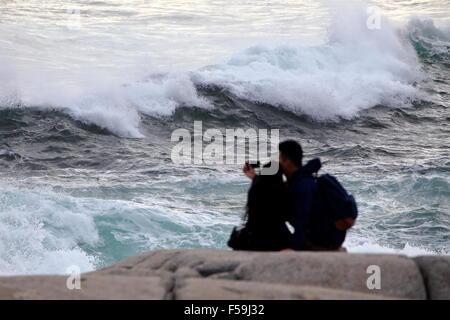 Ein paar oder zwei Menschen auf den Felsen bei Peggys Cove, Nova Scotia, die Nähe zu den Wellen und in der Gefahr des Ertrinkens. Stockfoto