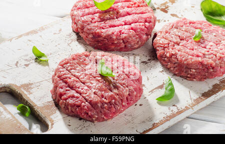 Rohen Boden Rindfleisch Burger Steak Bratlinge auf Holzbrett. Ansicht von oben Stockfoto