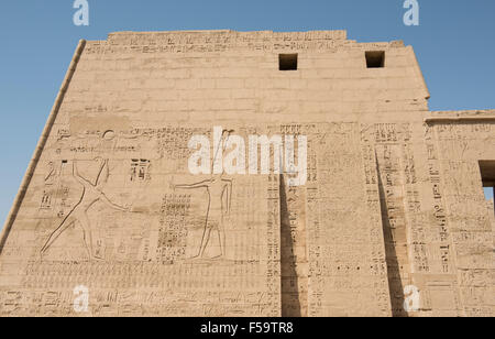 Ägyptische Hieroglyphen Schnitzereien auf großen Pylon Eingangswand am Tempel Medinat Habu Stockfoto