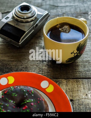 30. Oktober 2015 - Delicious Donut mit Streuseln auf Whie Platte, Cap Tee und Retro-Kamera auf hölzernen Verwitterung Tisch © Igor Goiovniov/ZUMA Draht/Alamy Live News Stockfoto