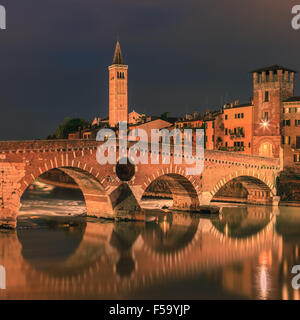 Ponte Pietra Bridge in der Dämmerung über der Etsch in Verona, Italien Stockfoto