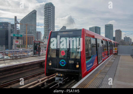 Ein roter Docklands Light Railway (DLR) Zug tragen eine Mohnblume nähert East India DLR Station, London, England, Vereinigtes Königreich Stockfoto