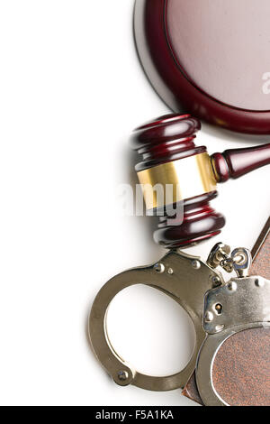 Handschellen und Richterhammer auf weißem Hintergrund Stockfoto