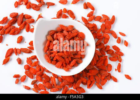 Getrocknete Goji Beeren in und neben kleinen Schüssel Stockfoto