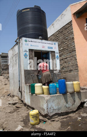 Frau mit Wasserbehältern sammeln erschwinglichen behandelt Trinkwasser Bohrloch Kamere Naivasha, Kenia Stockfoto