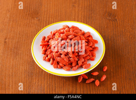 Haufen von getrockneten Goji-Beeren auf Platte Stockfoto