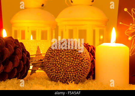 Weihnachten-Ambiente mit Kerzen, Tannenzapfen, Einkaufstaschen und Kugeln. Stockfoto